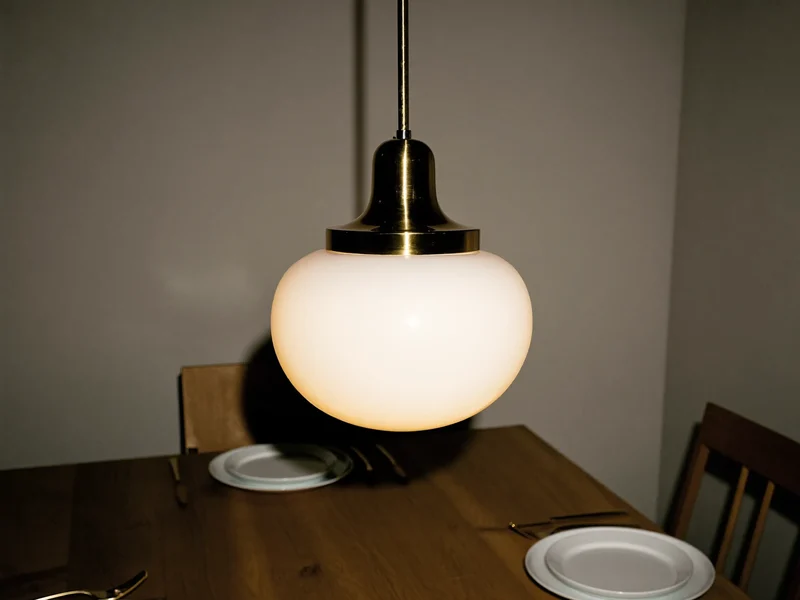 Pendul din alamă cu glob opal deasupra unei mese din stejar